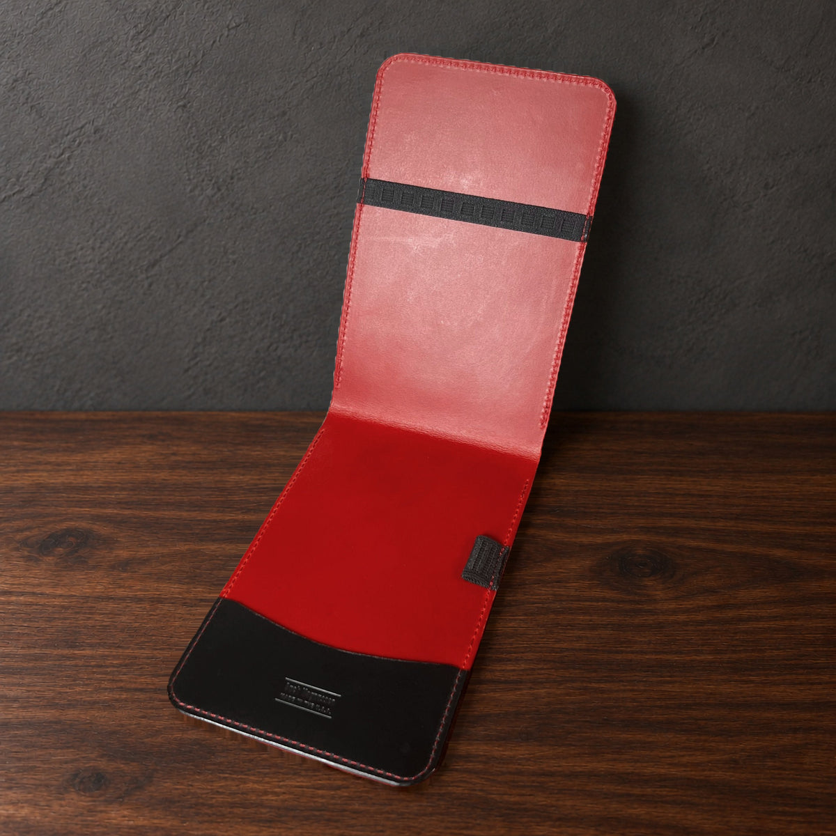 Augusta Classic yardage book cover in Black Buttero standing open, showing the red interior