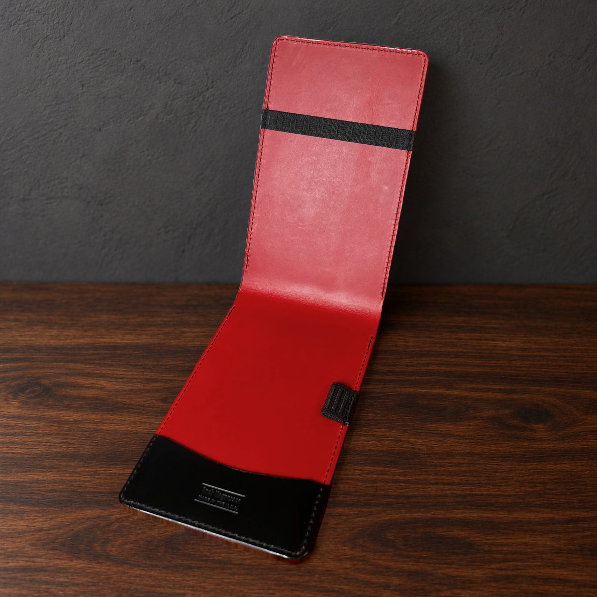 Augusta Pro yardage book cover in Black Buttero standing open, showing the red interior