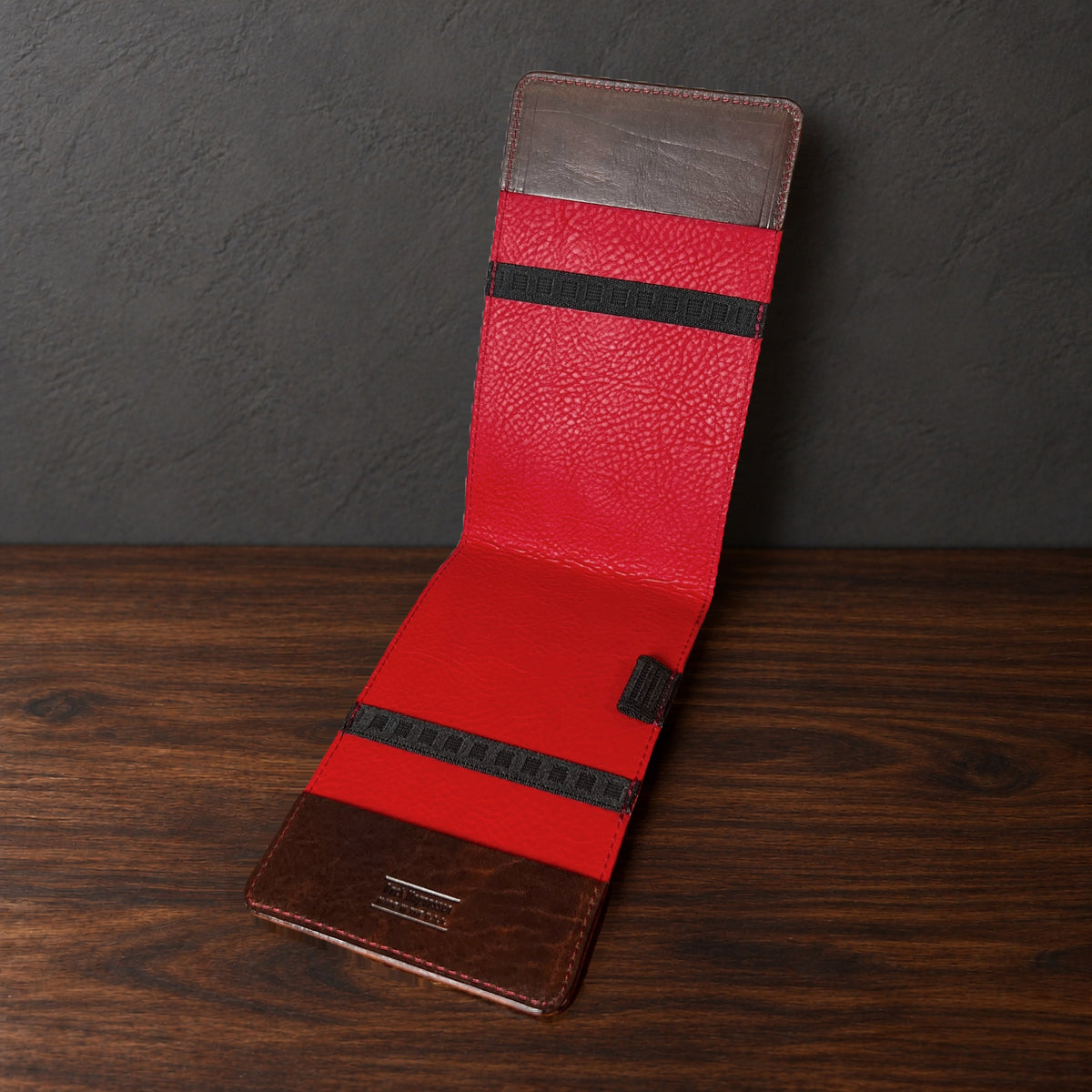 Oakmont Pro yardage book cover in Nemesis standing open, showing the red interior