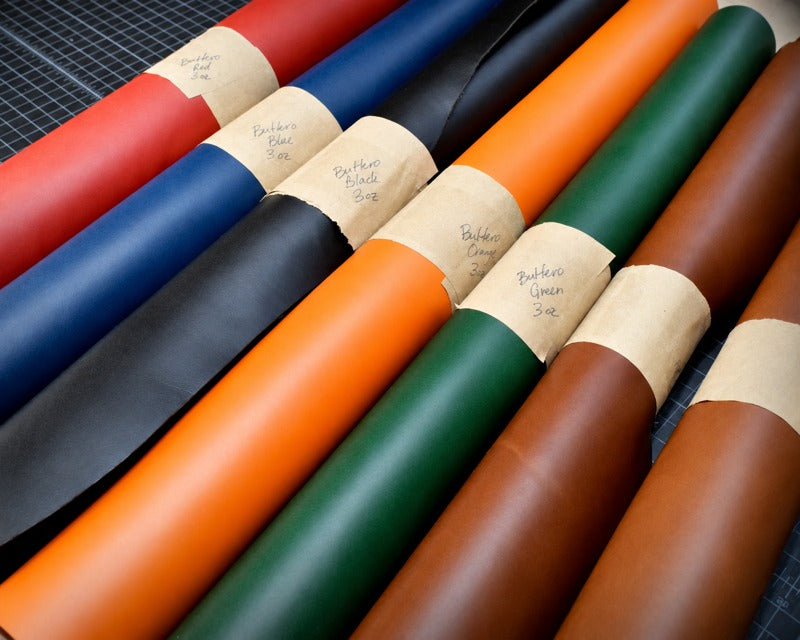 Rolls of Buttero leather in red, blue, black, orange, green and brown with kraft paper labels